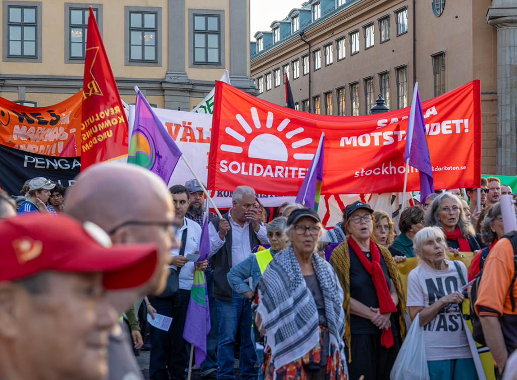Bild på demonstration inklusive Solidaritets banderoll i rött och vit logga.